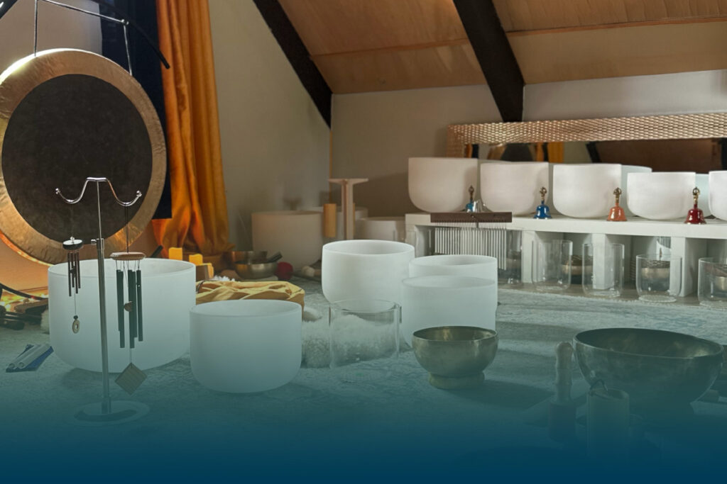 Image of a sound healing space at GlassWing Medicine of gongs crystal bowls, himalayan bowls and chimes in a sunlit room